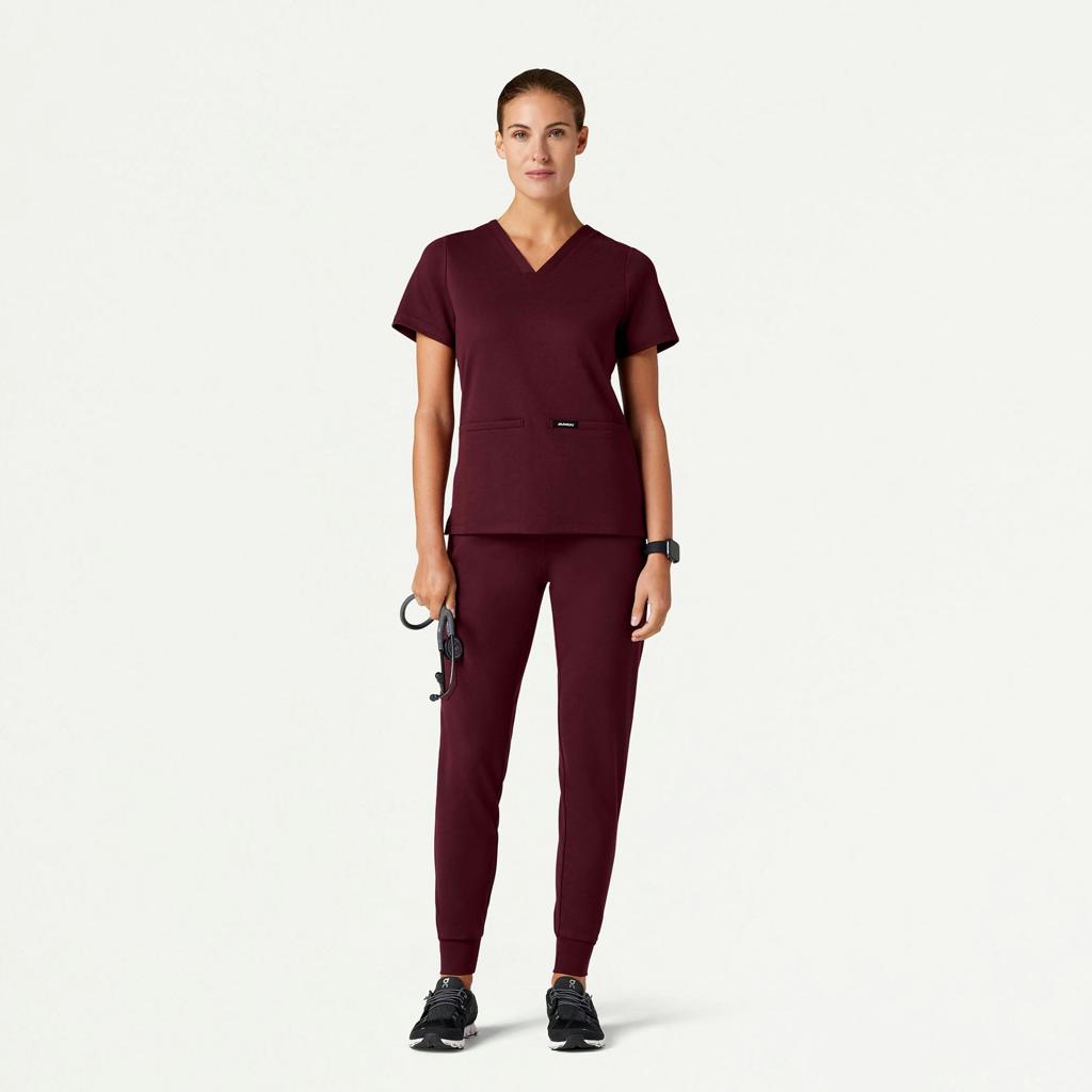 Healthcare professional modeling burgundy V-neck scrubs